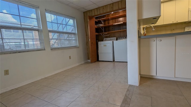 clothes washing area featuring washer and clothes dryer and light tile patterned flooring