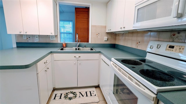 kitchen with white cabinets, white appliances, and sink