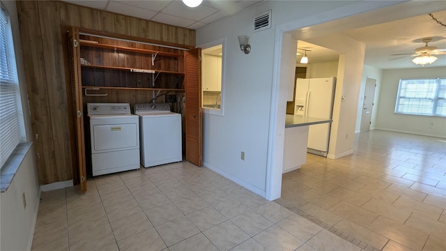 laundry room featuring light tile patterned floors, ceiling fan, and washing machine and clothes dryer