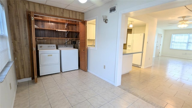 clothes washing area featuring ceiling fan, light tile patterned flooring, and independent washer and dryer