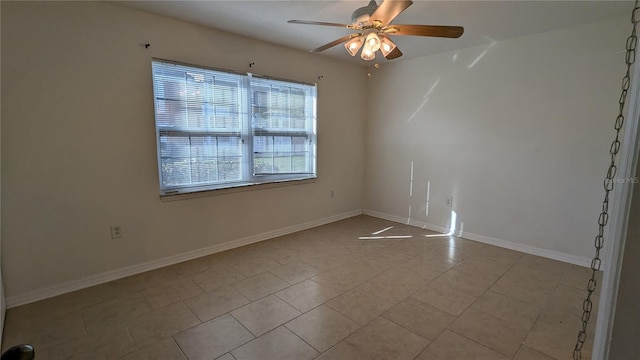 tiled spare room with ceiling fan