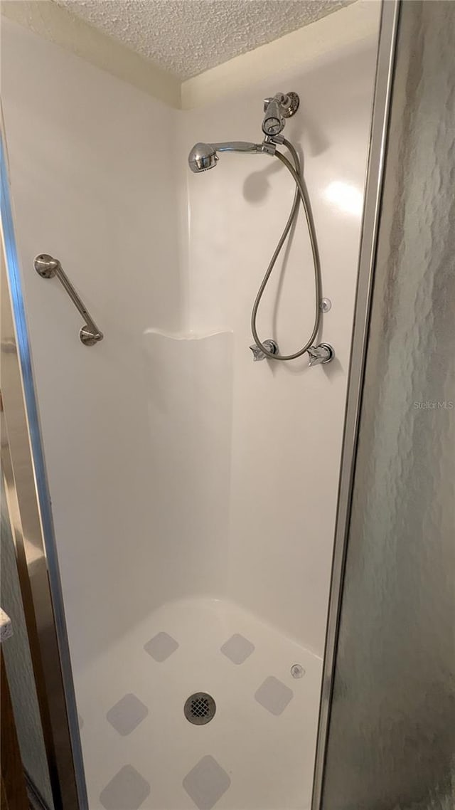 bathroom with a textured ceiling and walk in shower