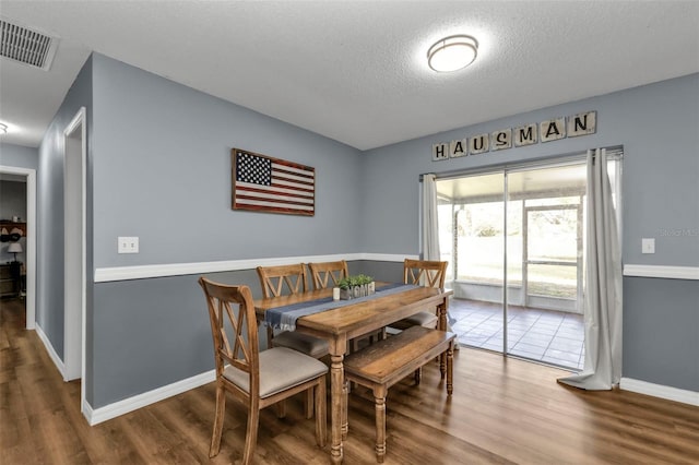 dining space featuring hardwood / wood-style floors and a textured ceiling