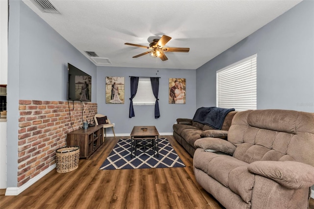 living room featuring a textured ceiling, dark hardwood / wood-style floors, and ceiling fan