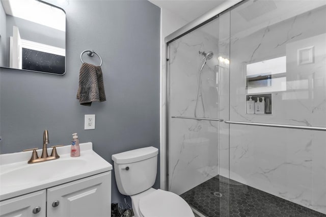 bathroom featuring vanity, toilet, and a shower with shower door