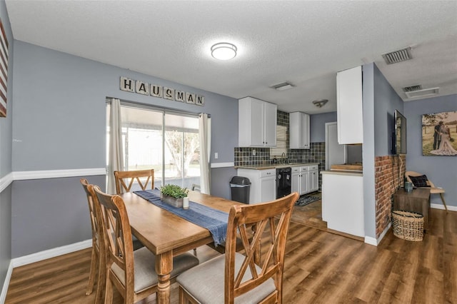 dining room featuring sink, dark hardwood / wood-style floors, and a textured ceiling