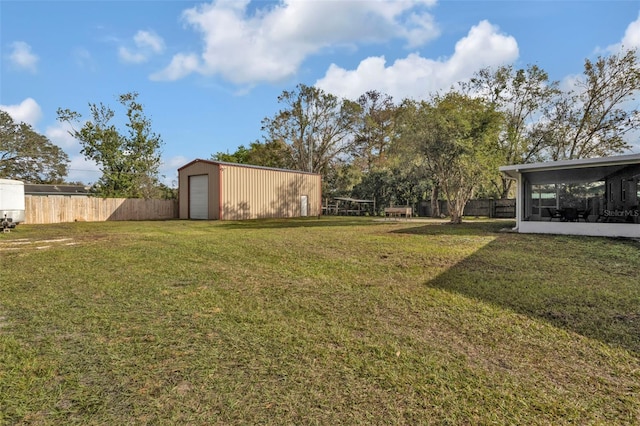 view of yard featuring an outbuilding, a garage, and a sunroom