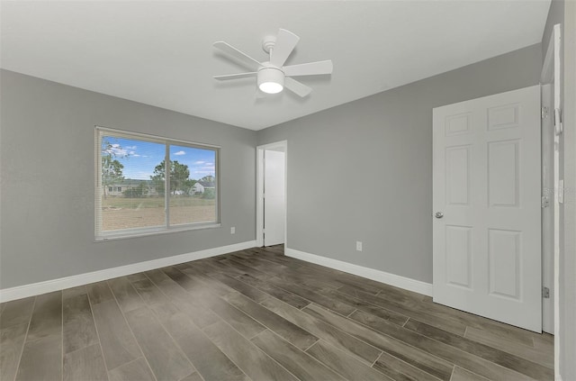 empty room featuring ceiling fan and dark hardwood / wood-style flooring