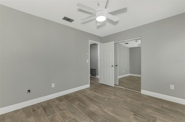 unfurnished bedroom with ceiling fan and a closet