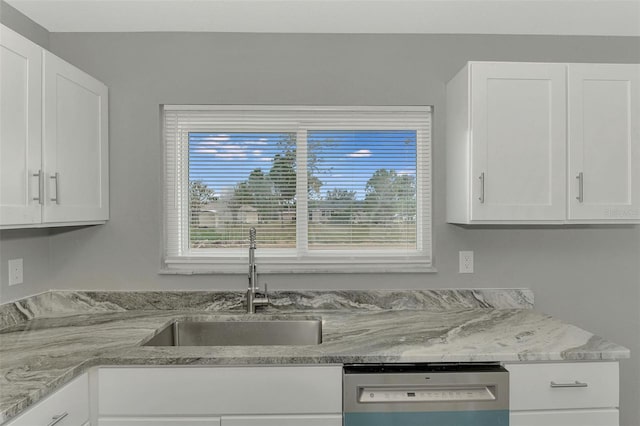 kitchen with dishwasher, light stone countertops, white cabinetry, and sink