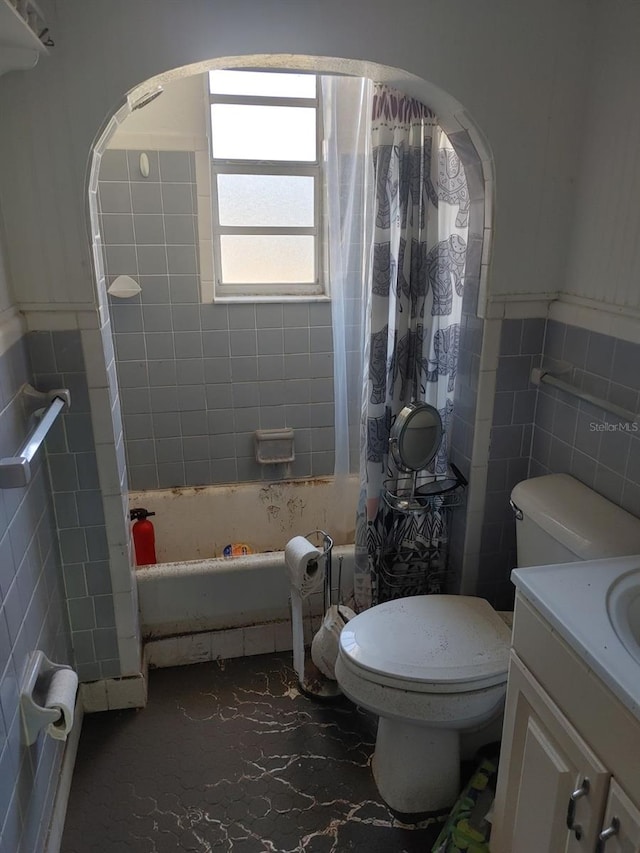 full bathroom featuring vanity, toilet, tile walls, and shower / tub combo