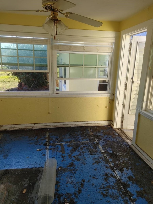 unfurnished sunroom with ceiling fan