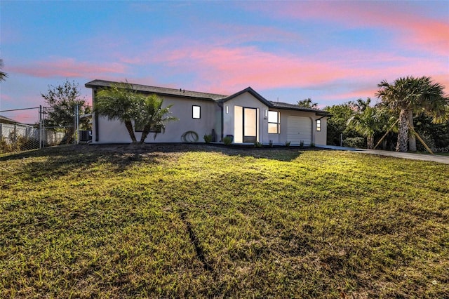 ranch-style house featuring a lawn and a garage