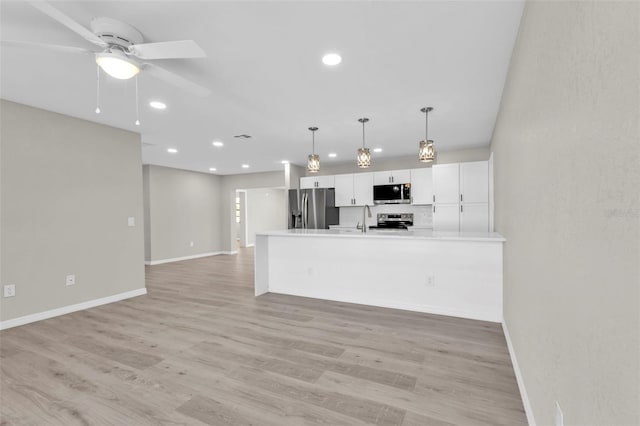 kitchen featuring white cabinetry, light hardwood / wood-style flooring, ceiling fan, and appliances with stainless steel finishes