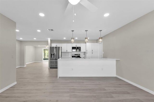 kitchen featuring white cabinetry, ceiling fan, hanging light fixtures, stainless steel appliances, and light hardwood / wood-style flooring