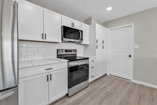 kitchen featuring light stone countertops, tasteful backsplash, stainless steel appliances, light hardwood / wood-style flooring, and white cabinets