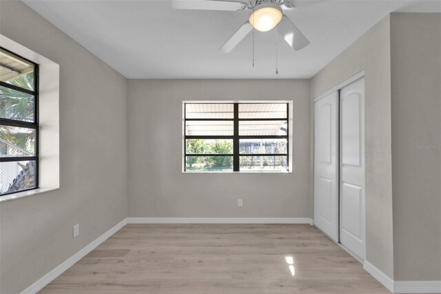 unfurnished bedroom with ceiling fan, light hardwood / wood-style floors, and a closet