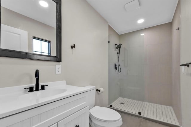 bathroom with a tile shower, tile patterned flooring, vanity, and toilet