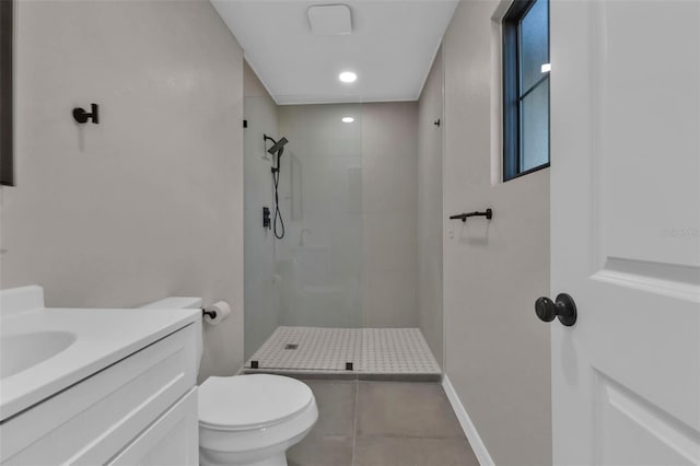 bathroom with tile patterned flooring, vanity, tiled shower, and toilet