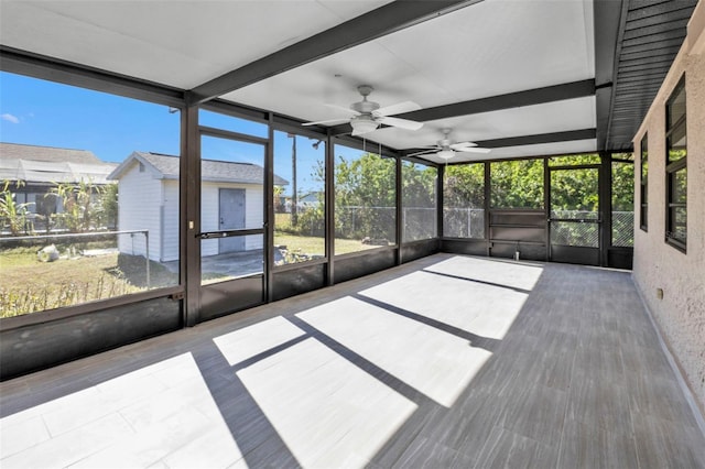 unfurnished sunroom with ceiling fan and beamed ceiling