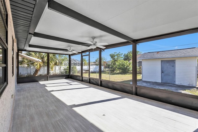 unfurnished sunroom with ceiling fan