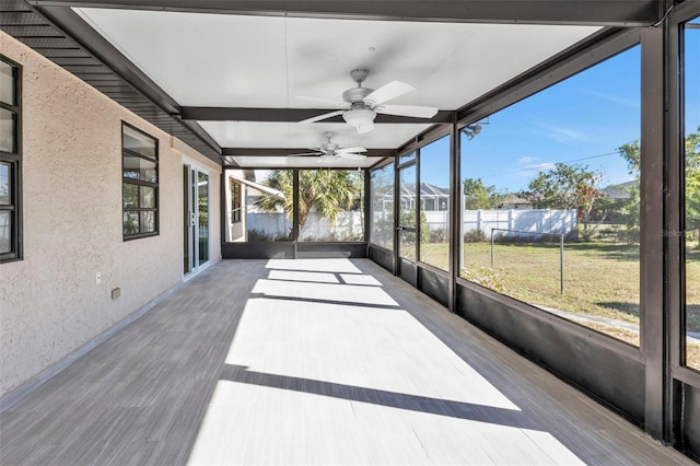 unfurnished sunroom featuring ceiling fan