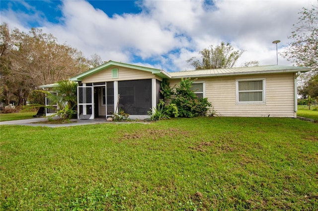 back of property featuring a yard and a sunroom