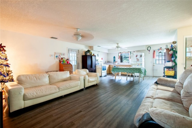 living room with ceiling fan, dark hardwood / wood-style flooring, and a textured ceiling