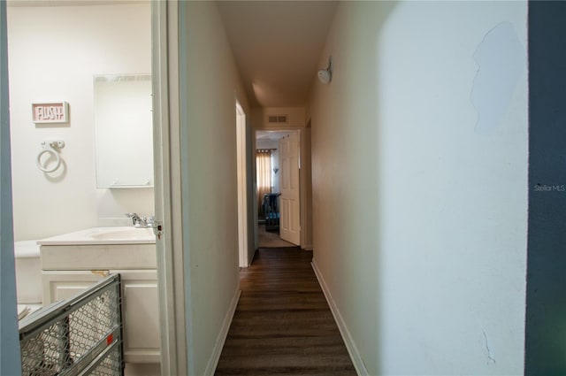 hall with sink and dark wood-type flooring