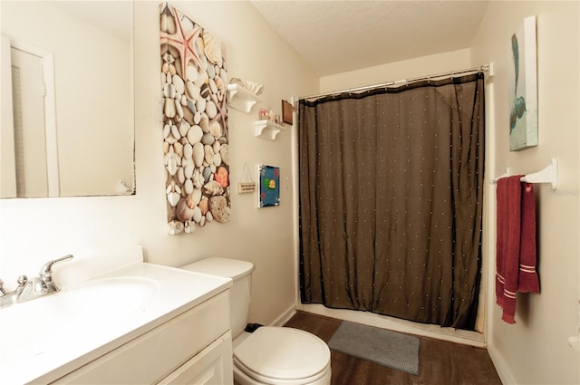 bathroom with a shower with shower curtain, vanity, a textured ceiling, hardwood / wood-style floors, and toilet