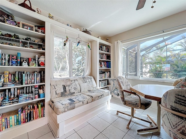 tiled office space featuring ceiling fan, a textured ceiling, and a wealth of natural light