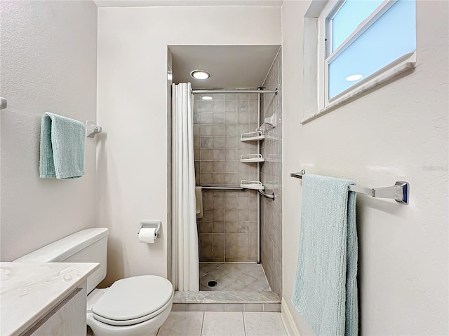 bathroom featuring a tile shower, vanity, toilet, and tile patterned floors