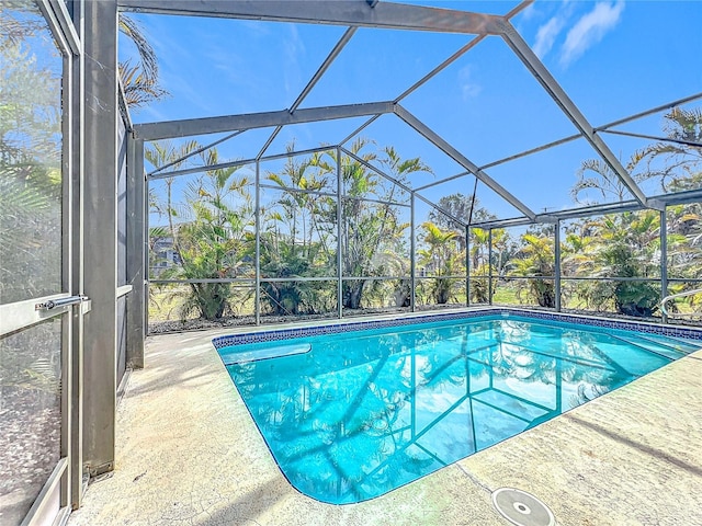 view of swimming pool with glass enclosure and a patio area