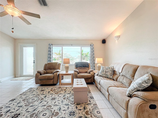 living room with ceiling fan, light tile patterned floors, and a textured ceiling