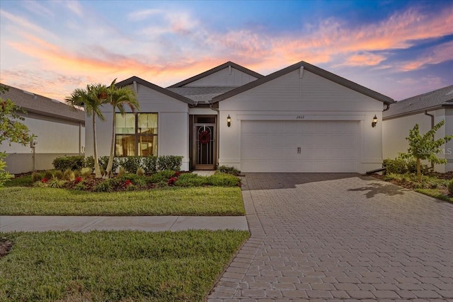 view of front of property with a garage and a yard