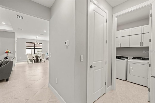 washroom with cabinets, separate washer and dryer, and light tile patterned floors