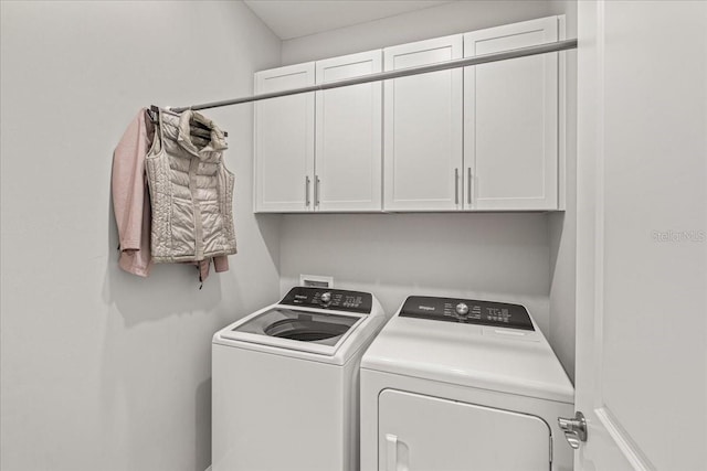 laundry area featuring washer and clothes dryer and cabinets