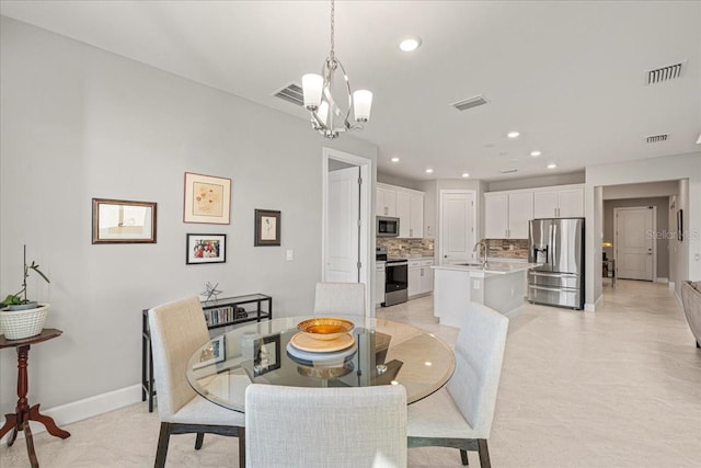 dining space featuring a chandelier, light tile patterned floors, and sink