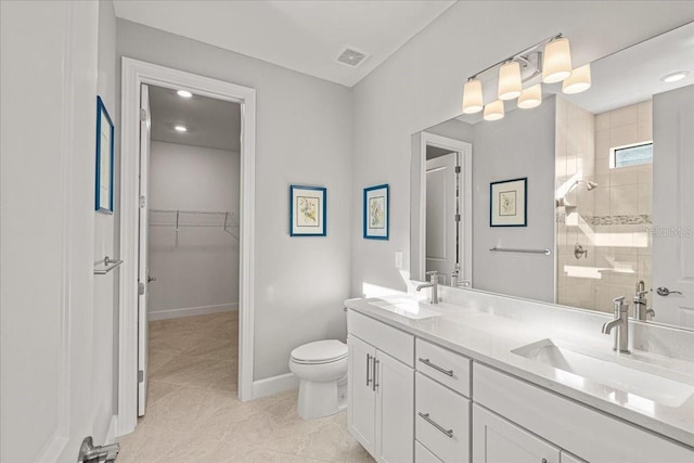 bathroom with tile patterned floors, vanity, toilet, and walk in shower