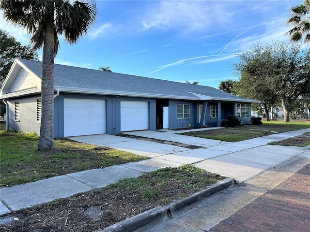 single story home featuring a garage and a front lawn