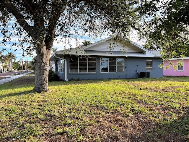 exterior space with central AC and a front lawn