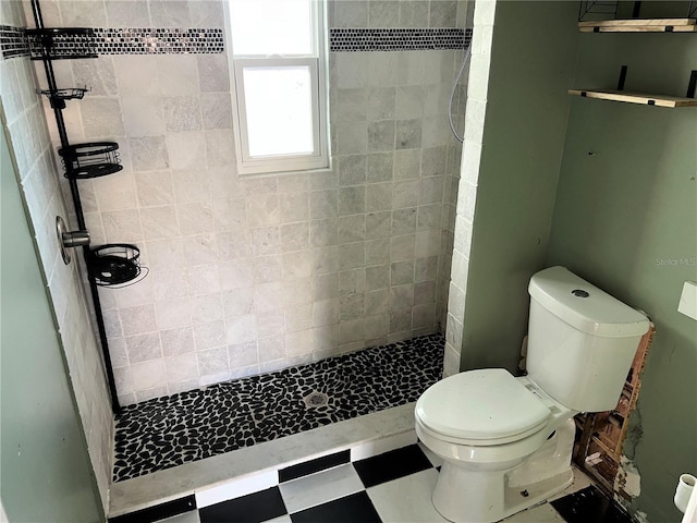 bathroom featuring tiled shower and toilet