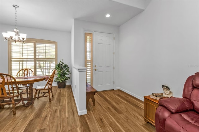 foyer entrance with light hardwood / wood-style flooring and a chandelier