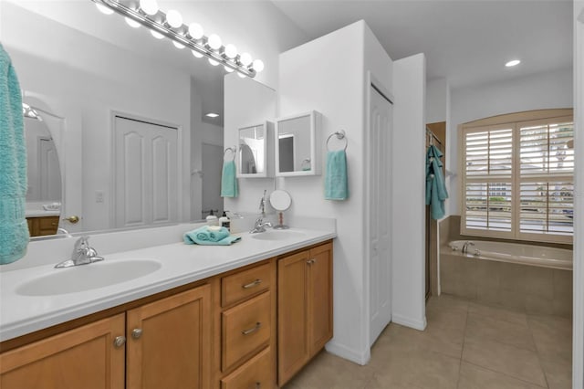 bathroom featuring tile patterned flooring, vanity, and a relaxing tiled tub