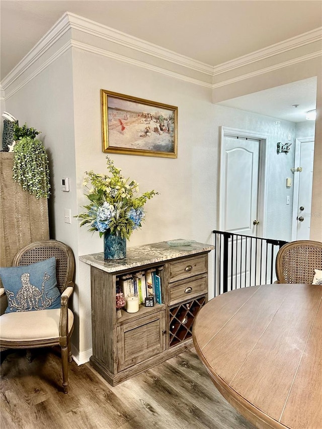 living area with crown molding and light hardwood / wood-style flooring