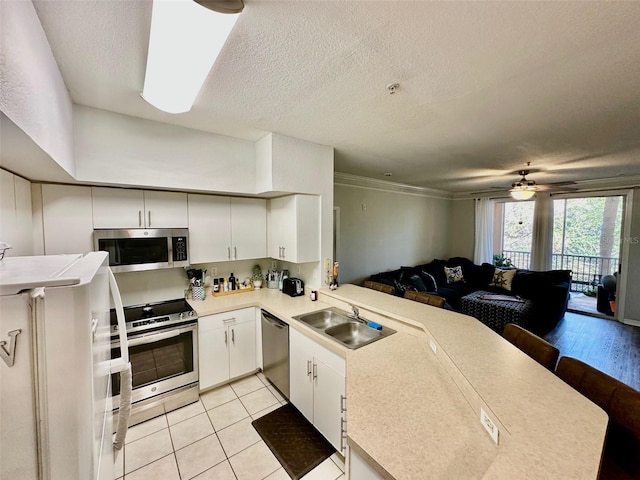 kitchen with white cabinets, kitchen peninsula, sink, and appliances with stainless steel finishes