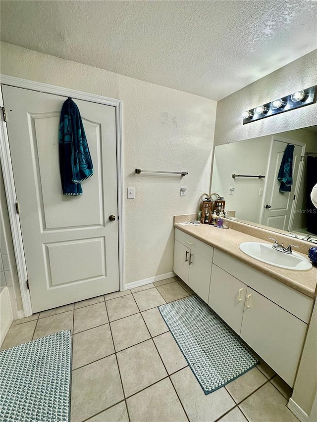 bathroom with tile patterned floors, vanity, and a textured ceiling