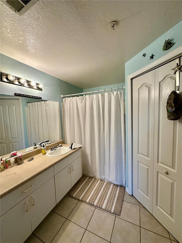 bathroom featuring vanity, a textured ceiling, and tile patterned floors