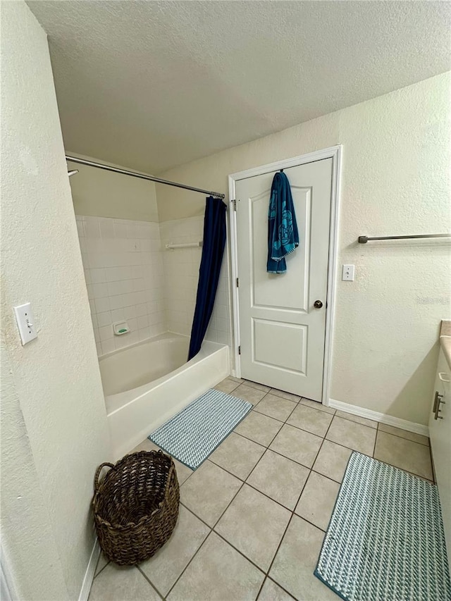 bathroom featuring a textured ceiling, a textured wall, shower / tub combo with curtain, and tile patterned floors