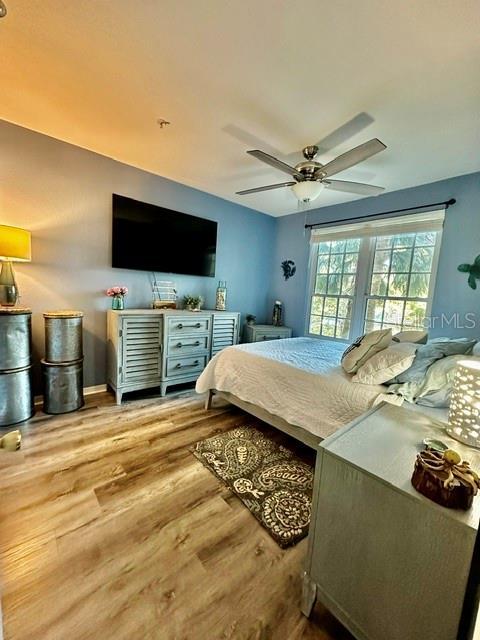 bedroom with a ceiling fan and wood finished floors